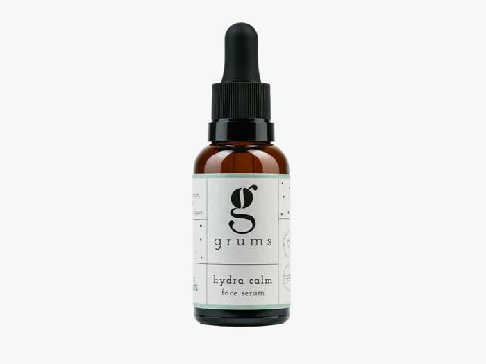 En brun glasdråbeflaske mærket grums hydra calm face serum med sort hætte og hvid etiket, der står oprejst på en hvid baggrund.