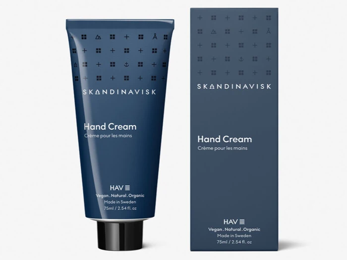 En marineblå tube og matchende æske med Skandinavisk Hand Cream, mærket vegansk, naturlig, økologisk, 75 ml, fremstillet i Sverige.