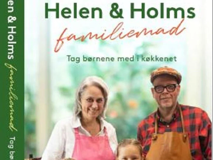 Forsiden af kogebogen Helen & Holms familiemad viser to voksne og to børn, der smiler i et køkken.