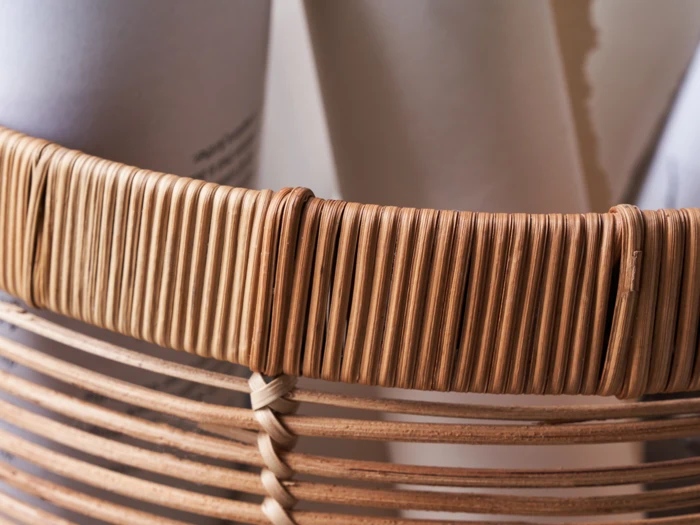 Nærbillede af en flettet kurv med sammenrullede ark af hvidt papir.