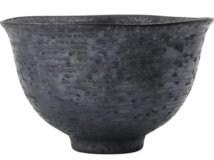 En mørkegrå keramikskål med en meleret, struktureret overflade og en let udsvajet kant på en hvid baggrund.