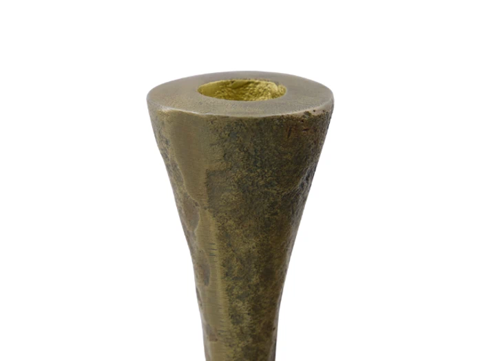 Et nærbillede af en konisk, struktureret bronze- eller messinggenstand med en hul åbning i toppen mod en hvid baggrund.