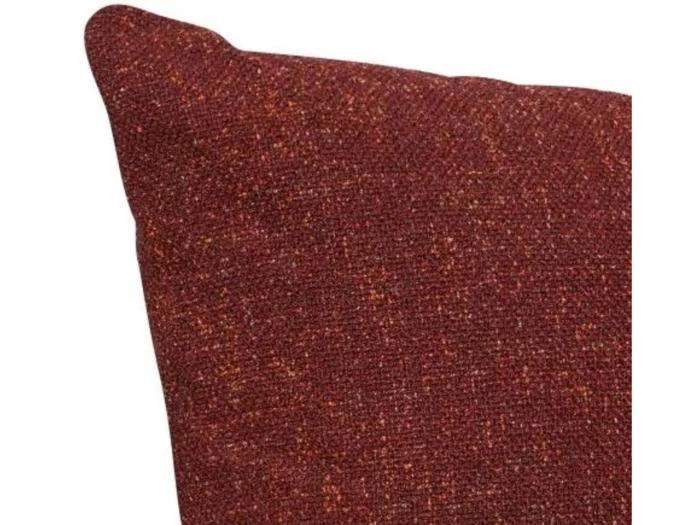 Nærbillede af en rødbrun struktureret stofpude med synlige vævede tråde og et let tilspidset hjørne.
