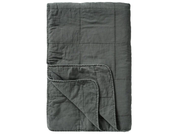 En foldet mørkegrå quilt med et syet firkantet mønster, vist med det ene hjørne vendt op for at afsløre undersiden.