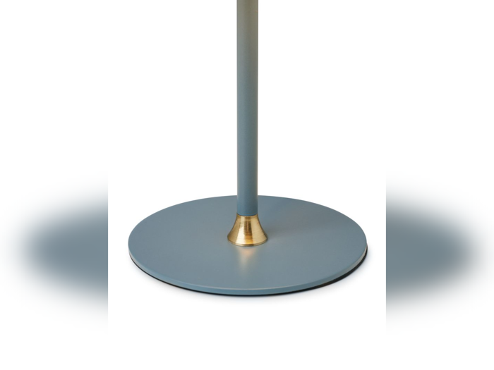 Et nærbillede af en rund, flad, blå base med en lodret stang og en lille guldaccent ved stangens tilslutningspunkt på en hvid baggrund.