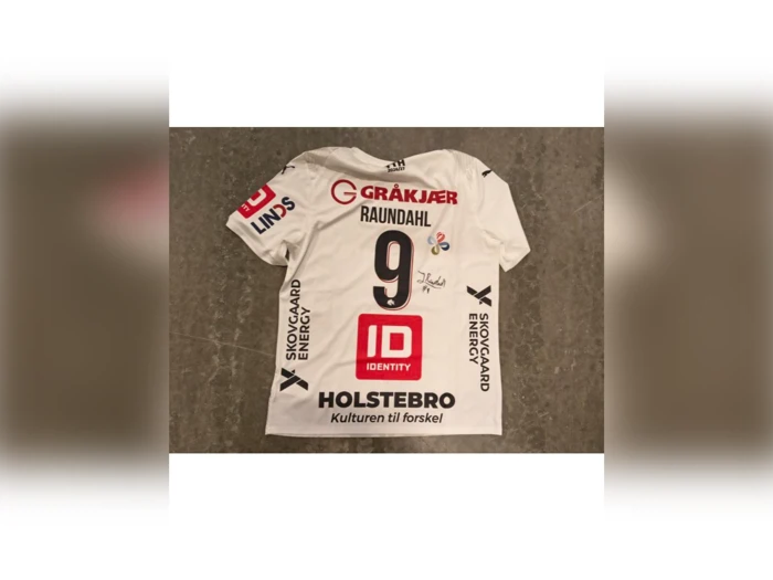 Hvid håndboldtrøje til spilleren Raundahl, nummer 9, med forskellige sponsorlogoer og en signatur på ryggen.