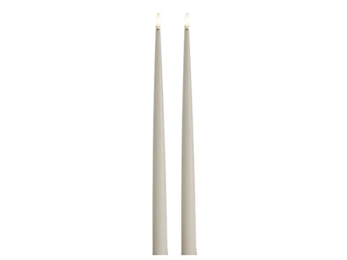 To høje, slanke, lysegrå koniske stearinlys med små flammer, der står oprejst på en hvid baggrund.