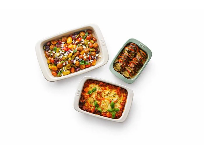 Tre ovnfade med ristede grøntsager, ratatouille og en pastaret med ost og basilikum på toppen.