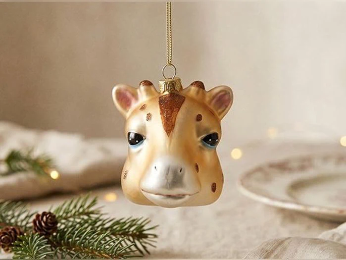 Julepynt i form af et girafhoved, der hænger i en guldtråd.