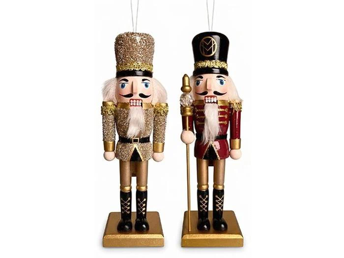 To nøddeknækker-pyntfigurer, der står på guldfodstykker; den ene er dækket af guldglitter, og den anden er iført en rød uniform med en guldstav.