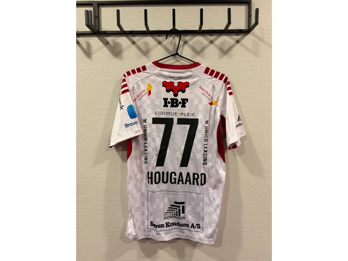 En hvid sportstrøje med røde detaljer hænger på en krog og bærer nummeret 77 og navnet HOUGAARD samt forskellige sponsorlogoer.