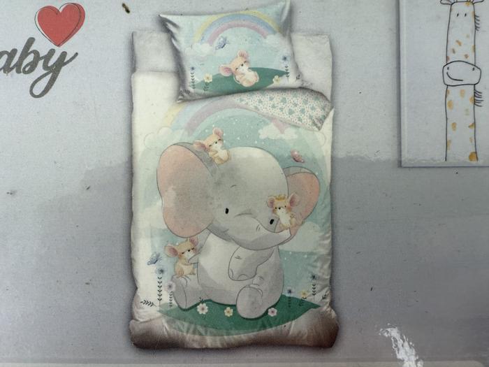 Sengesæt til børn med en sød grå babyelefant med store lyserøde ører, omgivet af sommerfugle, blomster og regnbuer på en pastelfarvet baggrund.