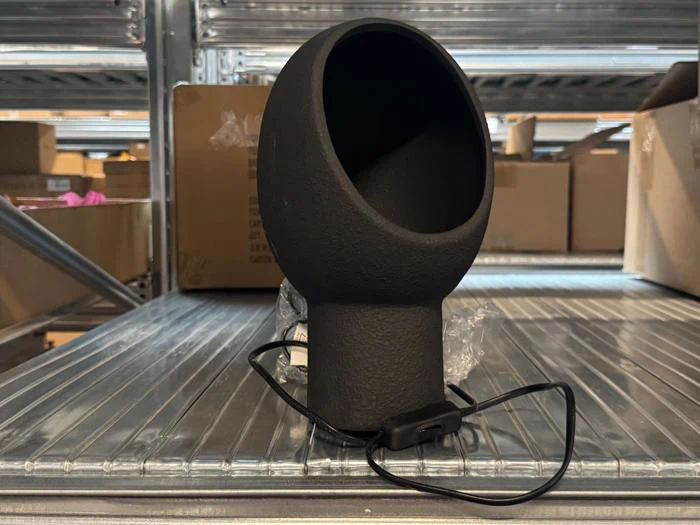 En sort, kugleformet bordlampe med en bred, åben forside og en ledning med en afbryder indbygget i ledningen.