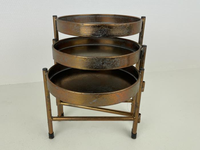 Et tredelt rundt metalstativ med en rustik bronzefinish med tre runde bakker stablet lodret på en metalramme.