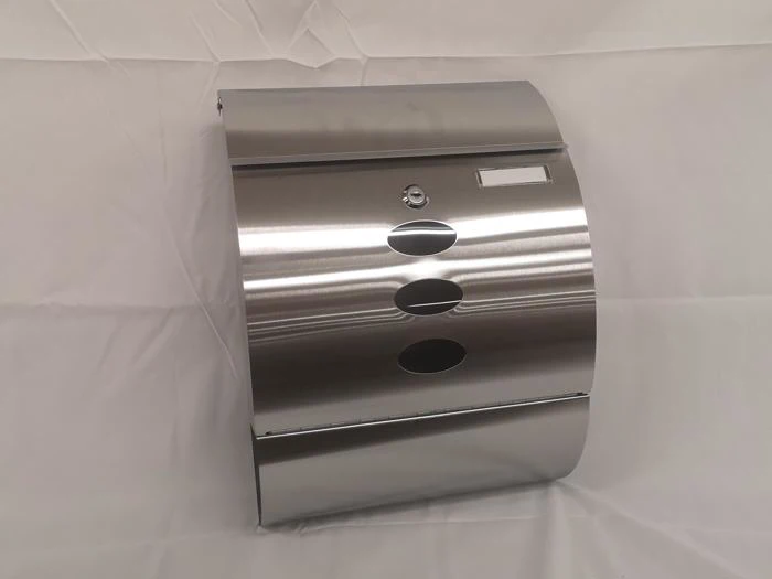 En vægmonteret papirhåndklædedispenser i rustfrit stål med tre ovale vinduer og en lås på en hvid baggrund.