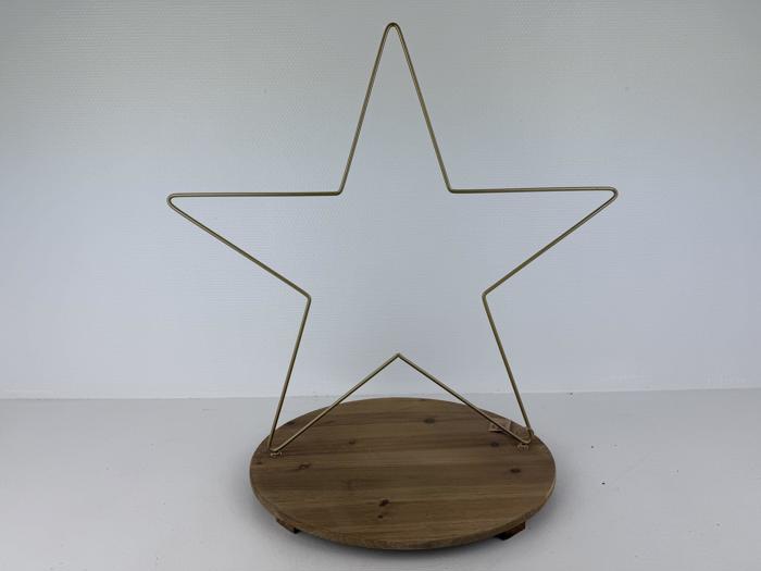 En stjerneformet ramme af guldmetal er fastgjort til en rund træbase på en almindelig hvid baggrund.