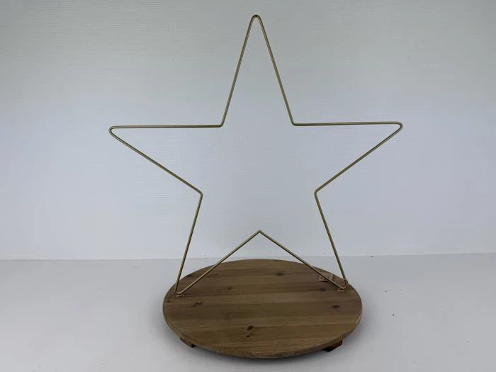 En stjerneformet ramme af guldmetal er fastgjort til en rund træbase på en almindelig hvid baggrund.