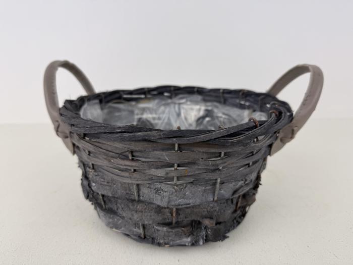 En rund, flettet kurv med to håndtag og en plastikforing indeni, placeret på en lys overflade mod en almindelig hvid baggrund.