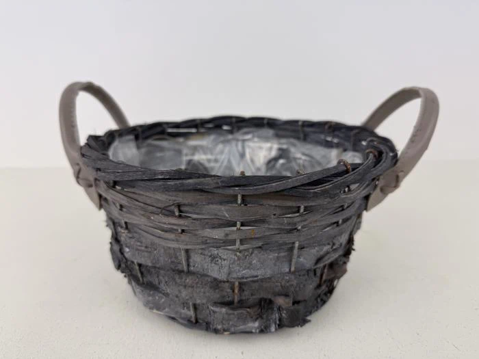 En rund, flettet kurv med to håndtag og en plastikforing indeni, placeret på en lys overflade mod en almindelig hvid baggrund.