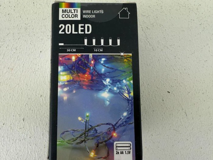 En æske med flerfarvede indendørs lyskæder med 20 LED'er, der drives af to AA-batterier. Æsken viser tændte lyskæder i forskellige farver og produktdetaljer.