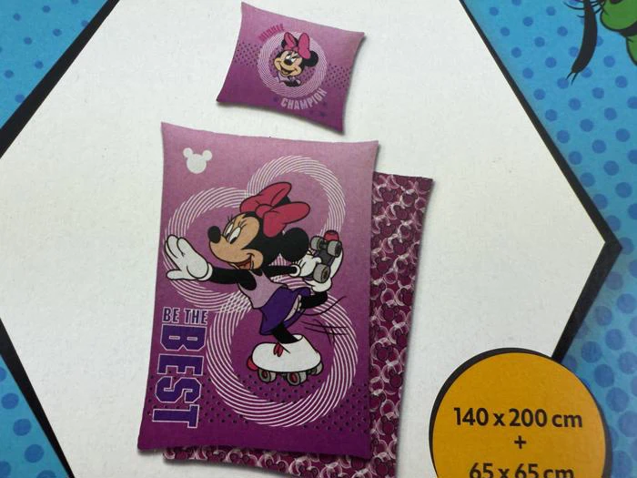 Lilla Minnie Mouse-sengesæt med Be the Best-tekst med Minnie på rulleskøjter; på det matchende pudebetræk står der Little Champion. Størrelserne er 140x200 cm og 65x65 cm.