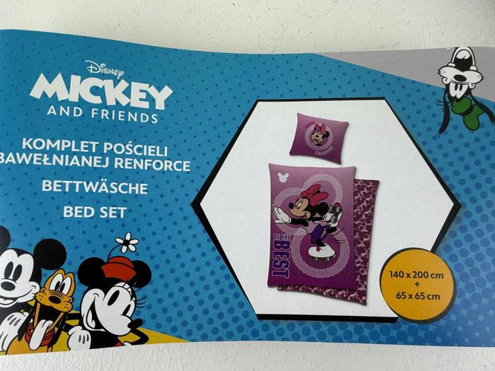 Emballage til Disney Mickey and Friends-sengesæt med billeder af Mickey, Pluto, Fedtmule og en lilla dyne og pude med Minnie Mouse-tema. Tekst på polsk, tysk og engelsk.