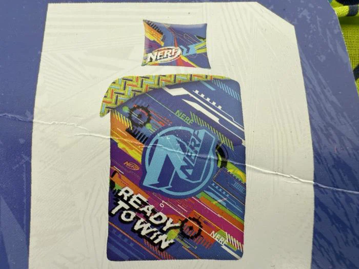 Farverig flaske med Nerf-tema med geometriske mønstre, teksten READY TO TOWN og Nerf-logoet på en hvid og blå baggrund.