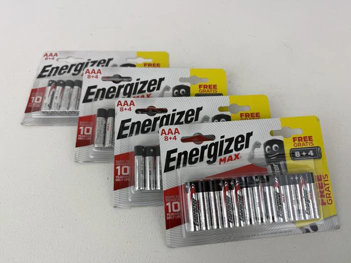 Fire pakker Energizer Max AAA-batterier (8+4 gratis i hver pakke) er anbragt i en række på en hvid overflade.