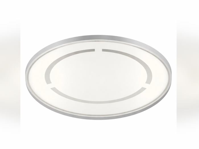 En rund, moderne loftslampe med matteret hvidt låg og sølvfarvet kant med tre korte, jævnt fordelte metalliske accenter på overfladen.