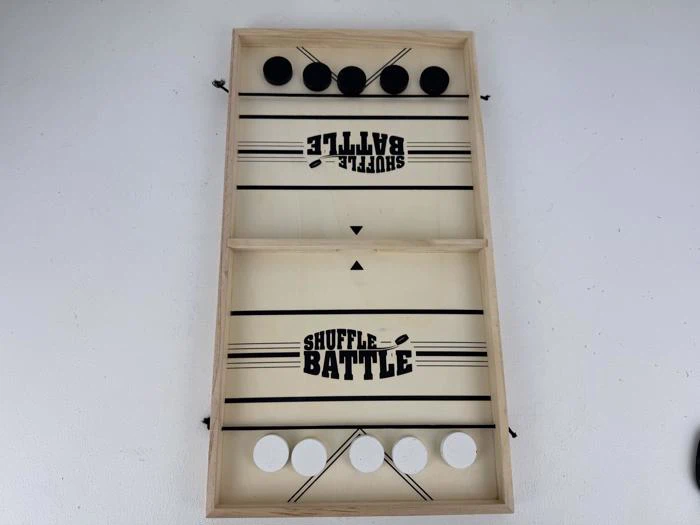 Et Shuffle Battle-brætspil i træ med fem sorte og fem hvide pucker placeret på hver sin side, klar til at blive spillet.