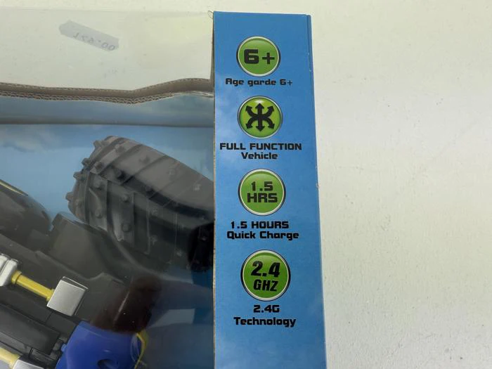 Æske med liste over funktioner: Aldersgruppe 6+, køretøj med fuld funktion, 1,5 timers hurtigopladning og 2,4 GHz-teknologi. En del af et legetøjskøretøj er synligt inde i emballagen.
