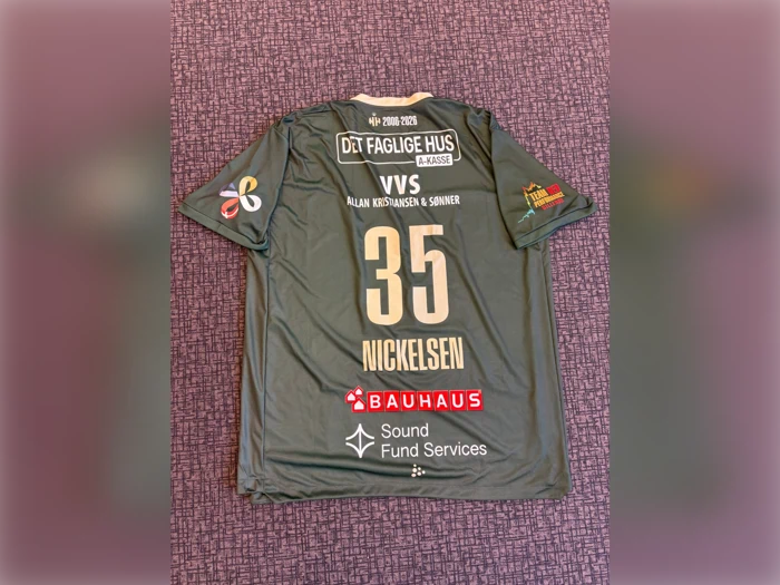 En grå sportstrøje med nummeret 35 og navnet NICKELSEN på ryggen, med forskellige sponsorlogoer og hvid tekst.