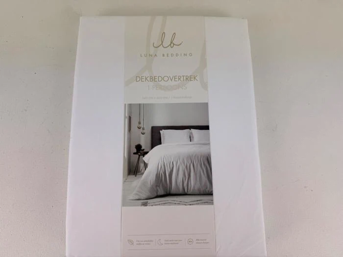 En pakke med Luna Bedding enkeltdynebetræk med et billede af en pænt redt seng med hvidt sengetøj og et moderne natbord.