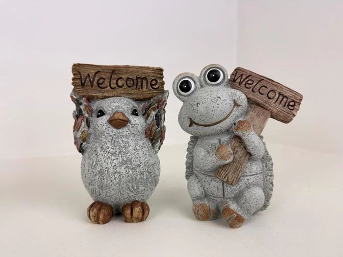 To søde figurer, en fugl og en frø, der hver især holder et velkomstskilt i træ, står side om side mod en almindelig hvid baggrund.