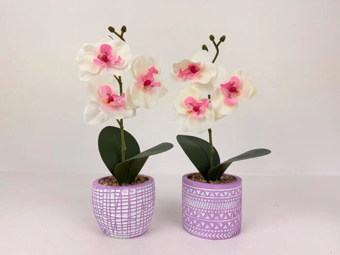 To kunstige orkidéer i potter med hvide og rosa blomster i dekorative lilla potter på en almindelig lys baggrund.