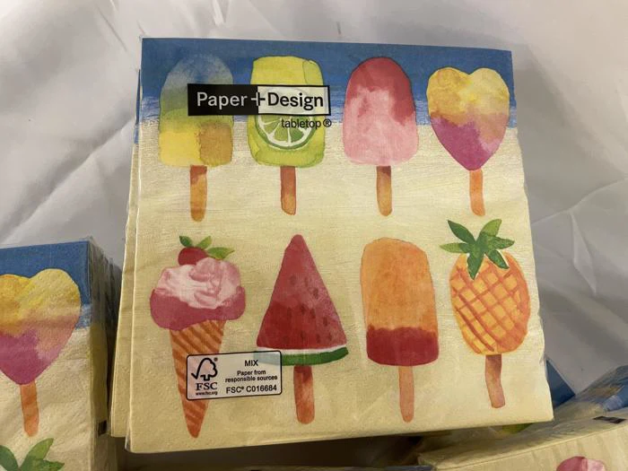 Farverige servietter med illustrationer af forskellige is og ispinde med frugttema, med Paper+Design bordbranding på emballagen.