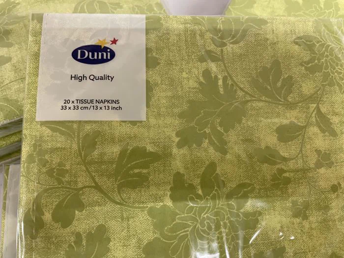 En pakke grønne, blomstermønstrede Duni-servietter, mærket High Quality, størrelse 33 x 33 cm (13 x 13 tommer), med 20 servietter i pakken.