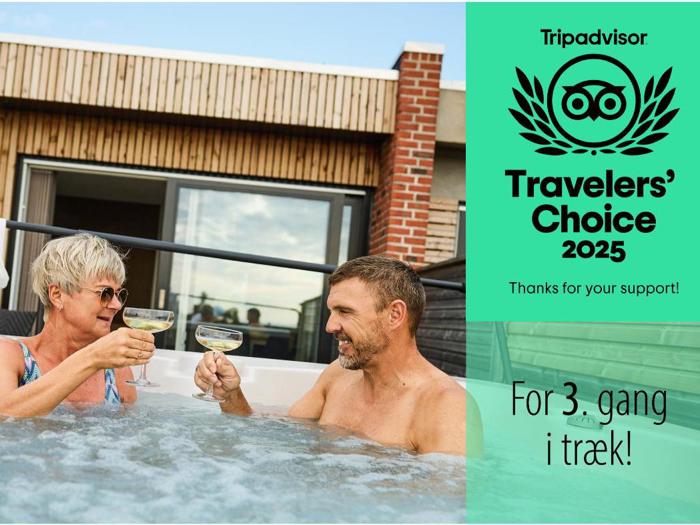 En ældre kvinde og en midaldrende mand skåler med champagne i et udendørs boblebad. Teksten lyder Travelers Choice 2025 og For 3. gang i træk! på højre side.