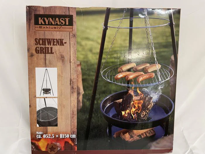 Æsken til en Kynast Schwenkgrill viser pølser, der tilberedes over bål på en ophængt grill. Æsken viser også et diagram og mål: Ø52,5 x H150 cm.