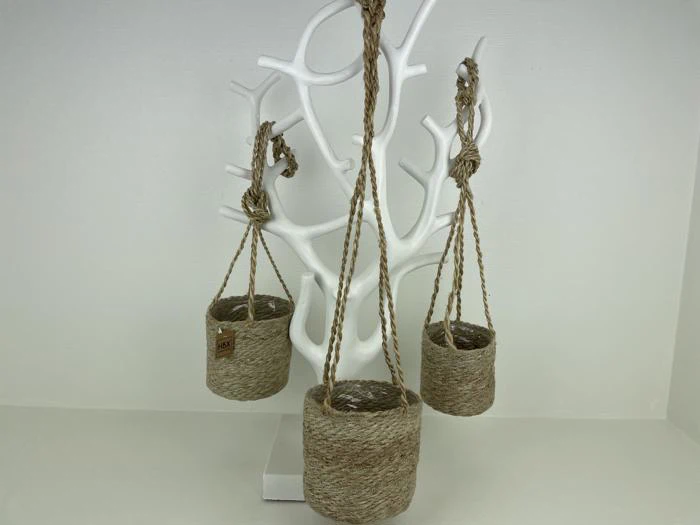 Tre små kurve af flettet reb hænger fra et hvidt, træformet stativ mod en almindelig lys baggrund.