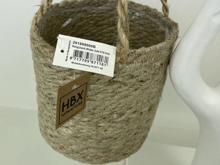 En vævet hængende kurv med rebhåndtag og to tags: et med produktoplysninger og en stregkode og et andet med teksten HBX we love living.