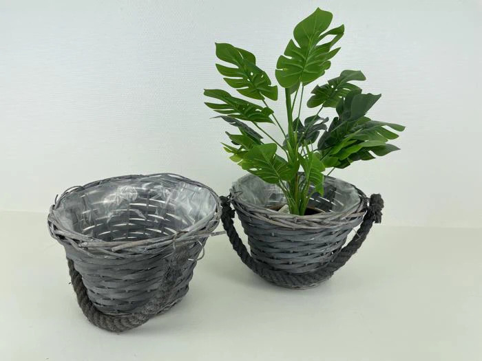 To grå flettede kurve med håndtag af reb; den ene er tom, og den anden indeholder en lille grøn potteplante. Begge er placeret på en lys overflade mod en almindelig baggrund.