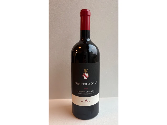 En flaske Fonterutoli 2021 Chianti Classico-rødvin med mørk etiket og rød foliehætte, der står på en hvid overflade.