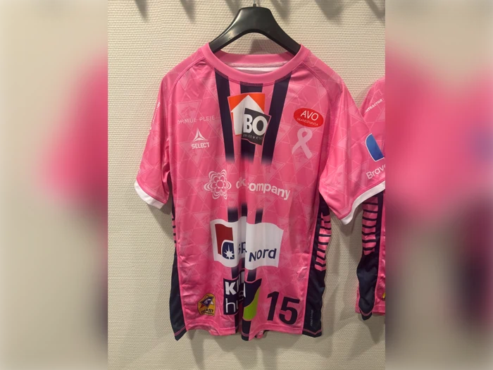 Lyserød og marineblå kortærmet sportstrøje med forskellige sponsorlogoer, et bånd til støtte for kampen mod brystkræft og tallet 15 på forsiden.