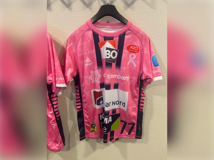En lyserød sportstrøje med forskellige sponsorlogoer og tallet 77 på forsiden.