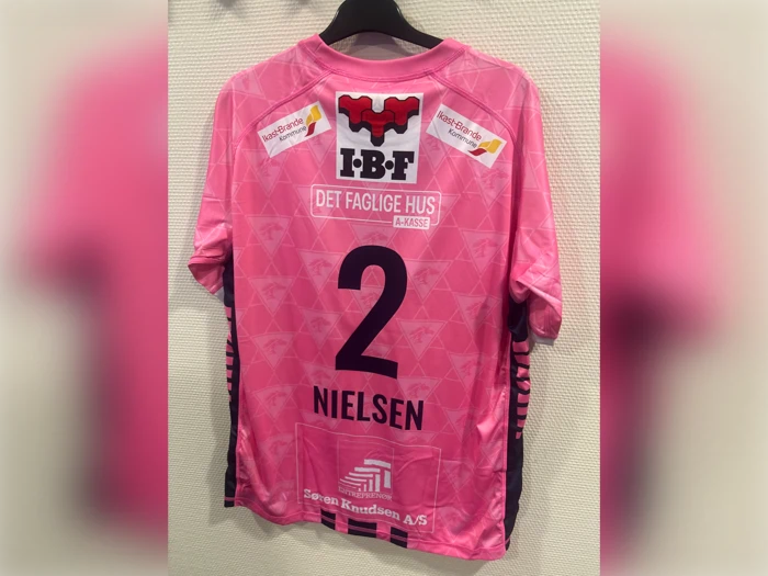 Lyserød trøje med nummer 2 og navnet NIELSEN på ryggen, med flere sponsorlogoer og tekster, herunder IBF og DET FAGLIGE HUS.