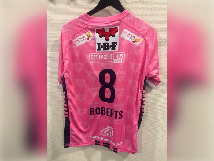 Lyserød trøje med nummer 8 og navnet ROBERTS på ryggen, med forskellige sponsorlogoer.
