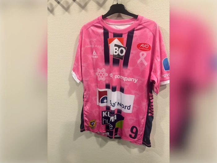 Lyserød sportstrøje med korte ærmer, sorte sidepaneler, nummer 9 og forskellige sponsorlogoer trykt på forsiden.