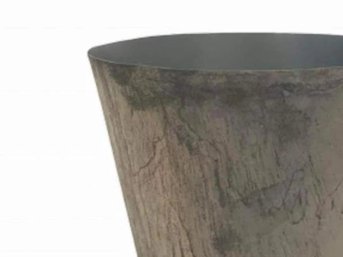 Nærbillede af en høj, cylindrisk, brun potte med gråt indre og en struktureret, forvitret overflade.