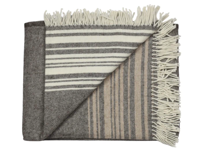 Et foldet uldtæppe med frynser, med mørke- og lysegrå striber på den ene side og beige- og brune striber på den anden.